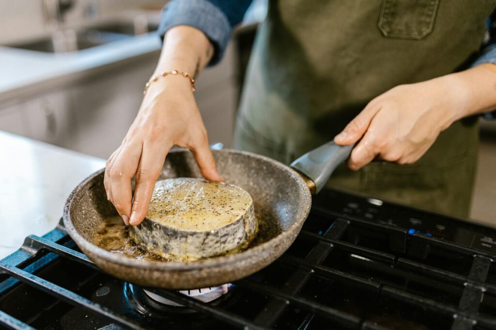 A frying pan sitting unevenly on a glass cooktop during a cookware inspection