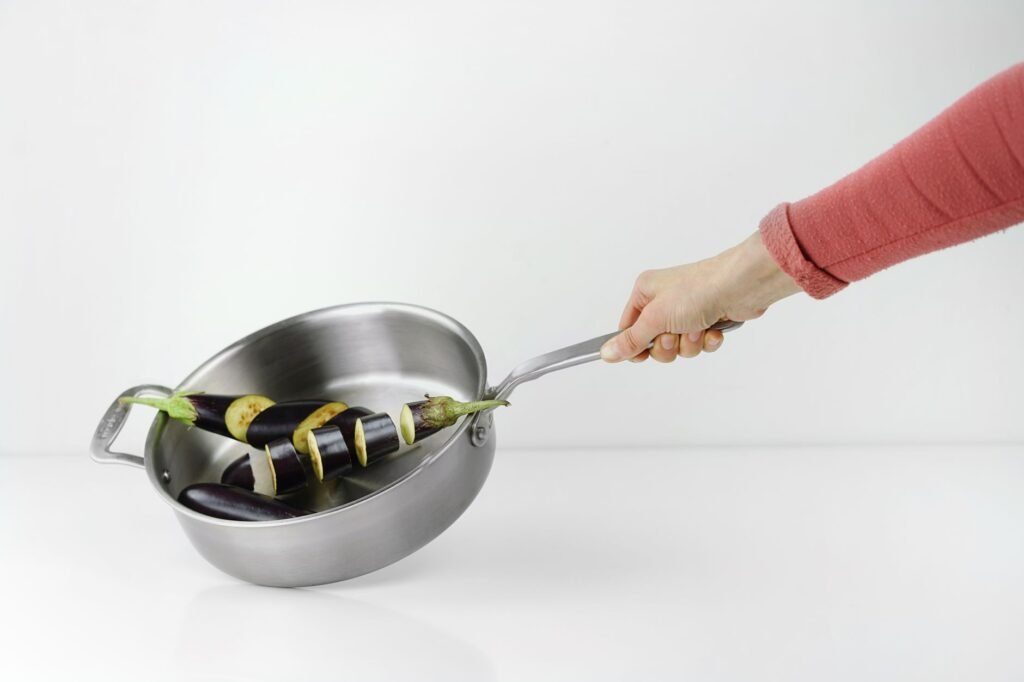 A calculator, receipts, and two everyday pans on a kitchen counter