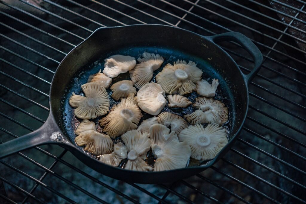A cast-iron skillet with seasoning oil and a scrub brush on a kitchen counter