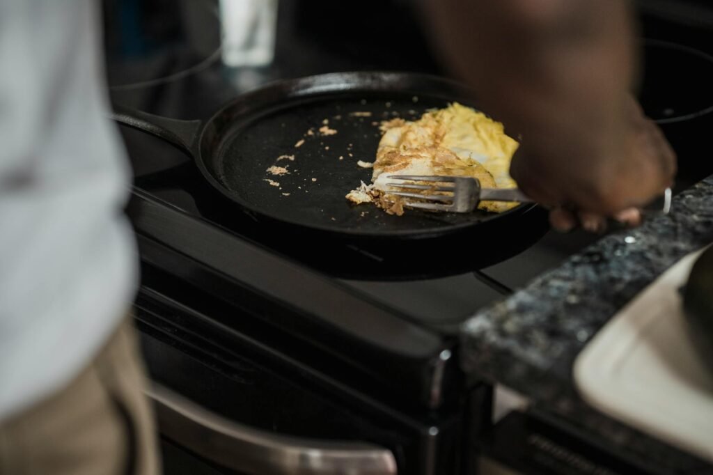 Different pans arranged with eggs, tomatoes, and steak ingredients to show cooking uses